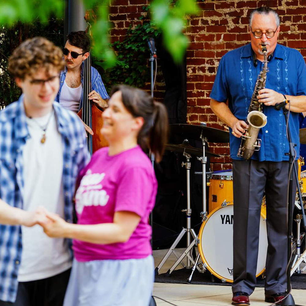 Two people dance together as a jazz band plays in the background