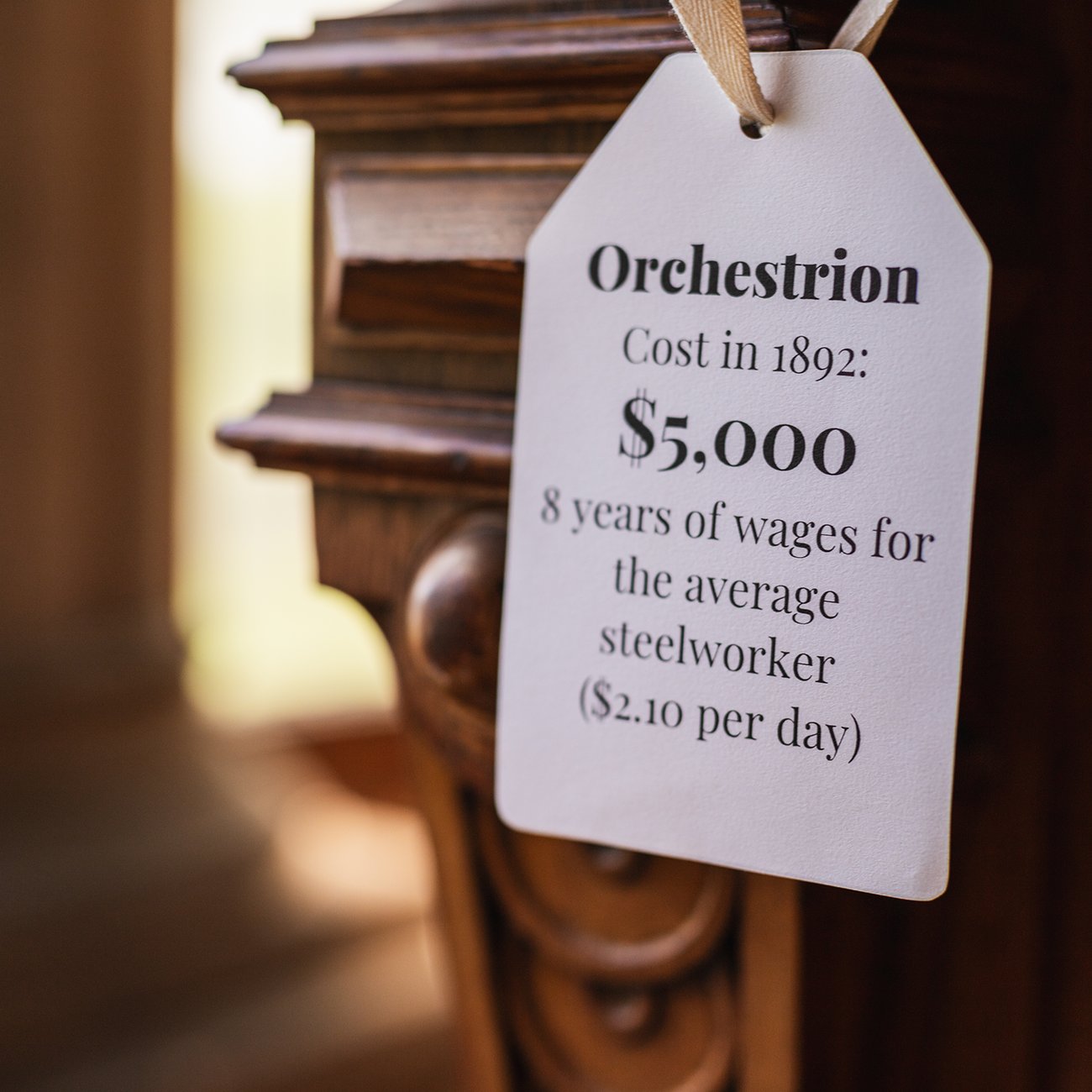 A label in a historic home demonstrates the price of an object compared to steel worker's wages in the time period